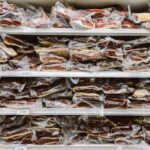Vacuum-sealed cuts of beef stacked in a freezer, showing bulk meat storage and organization