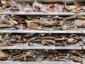 Vacuum-sealed cuts of beef stacked in a freezer, showing bulk meat storage and organization
